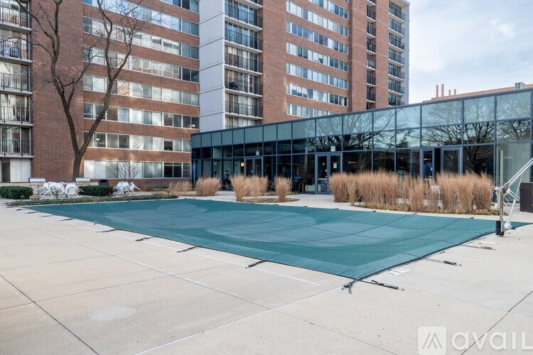 A large green swimming pool in front of a building.