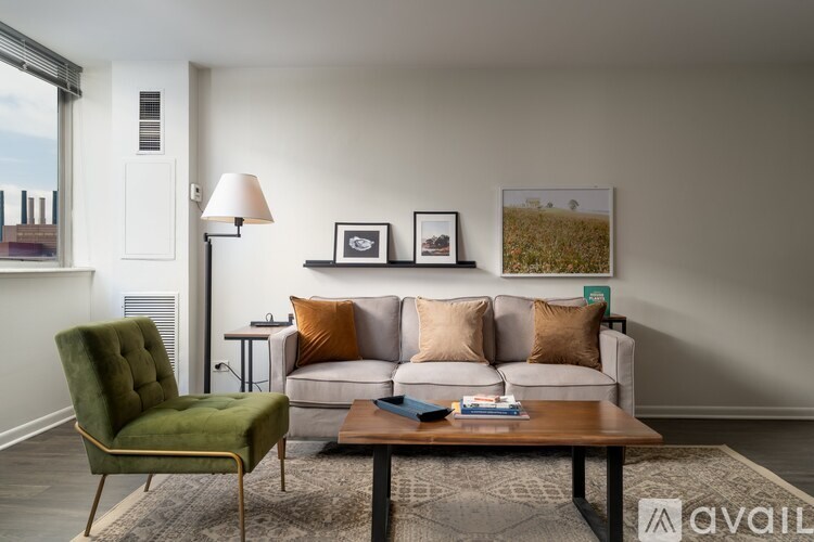 A living room with a green chair, a white couch, and a coffee table.