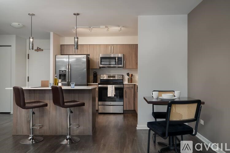 A modern kitchen with a bar area and a dining table set for two.