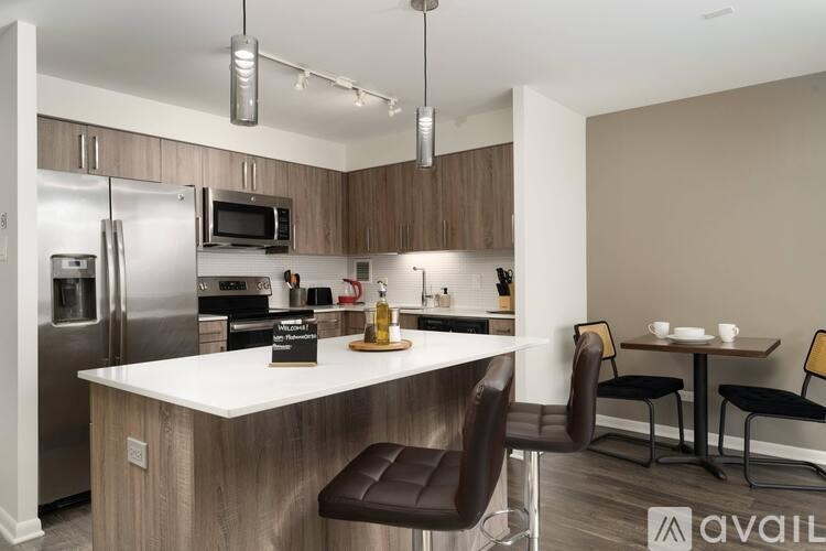 A kitchen with a white countertop and brown chairs.