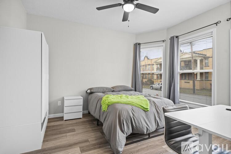 A bedroom with a bed, desk, and chair.