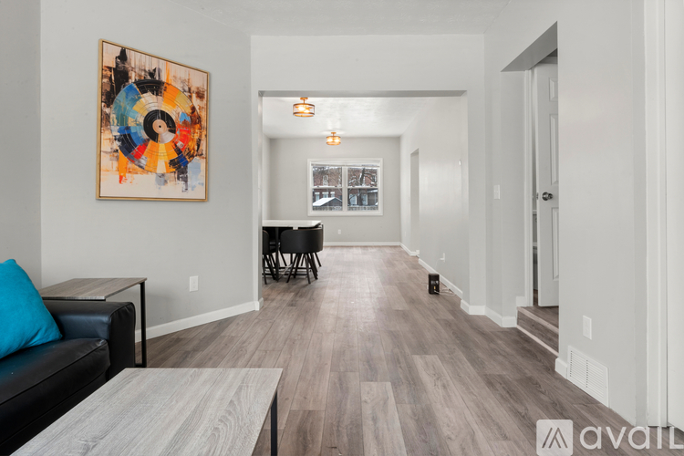 A living room with a couch, coffee table, and a painting on the wall.
