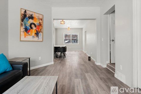 A living room with a couch, coffee table, and a painting on the wall.