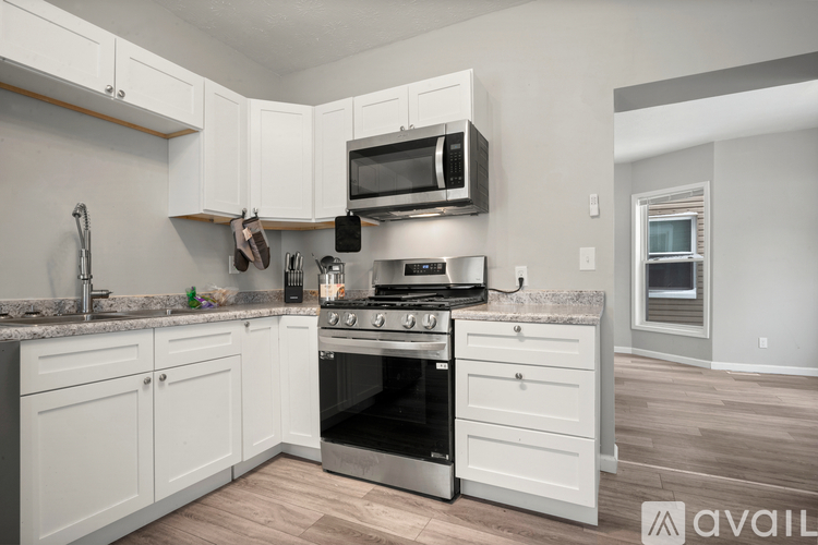 A kitchen with white cabinets and a stainless steel oven.