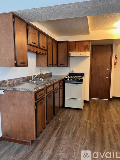 A kitchen with wooden cabinets and a white stove top oven.