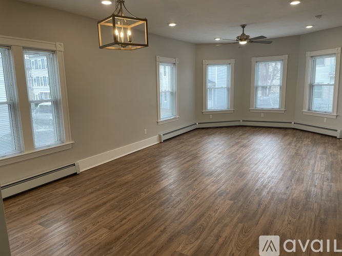 A room with wooden flooring and a ceiling fan.