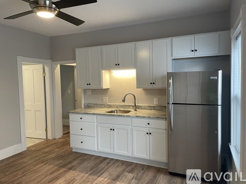 A kitchen with white cabinets and a stainless steel refrigerator.