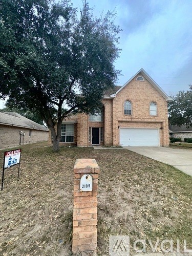 A house with a sign in front of it is for sale.