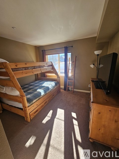 A bedroom with a bunk bed and a television.
