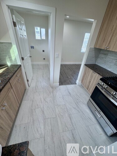 A kitchen with a black oven and wooden cabinets.