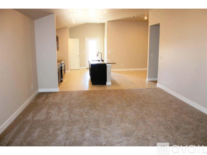 A room with a carpeted floor and a suitcase in the middle.