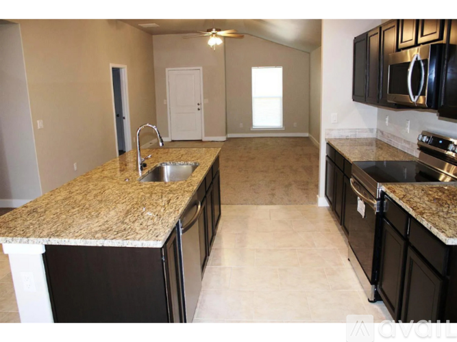 A kitchen with granite countertops and black cabinets is available for rent.
