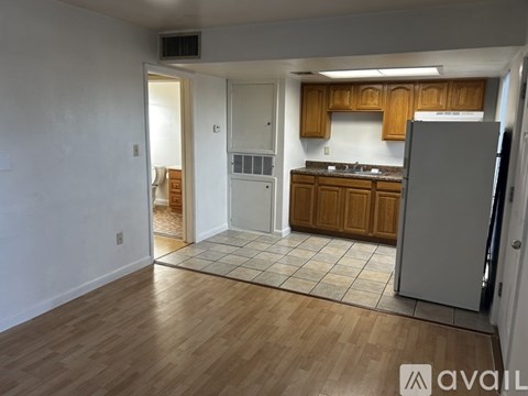 A kitchen with wooden cabinets and a refrigerator.