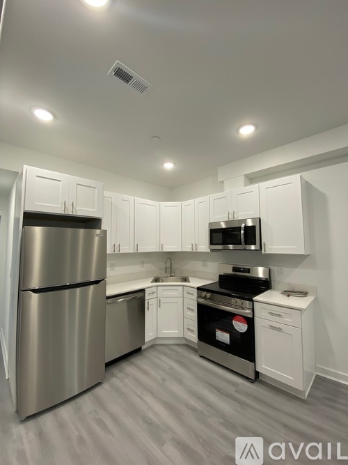 A kitchen with white cabinets and a stainless steel refrigerator.