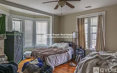 A bedroom with two beds and a ceiling fan.