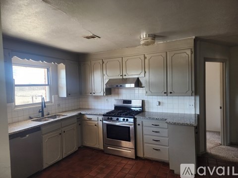 A kitchen with white cabinets and a tile backsplash.