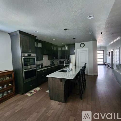 A kitchen with dark wood cabinets and a white island.