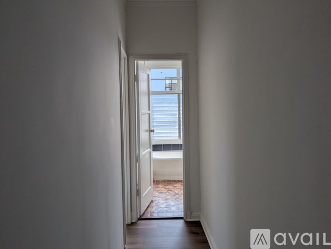 A hallway with a door leading to a balcony.