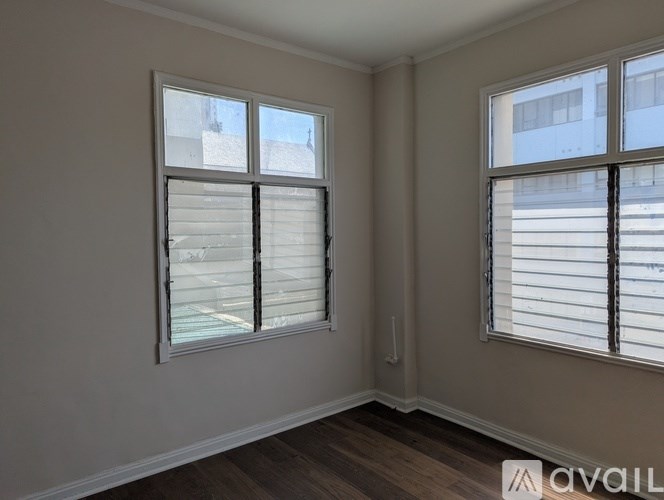 A room with two windows, one of which has blinds.
