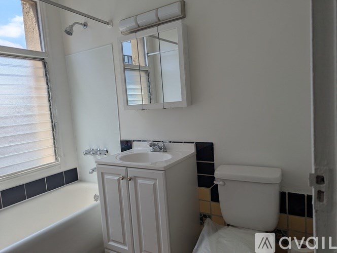 A white bathroom with a tub, sink, and toilet.