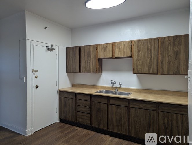 A kitchen with wooden cabinets and a white door.