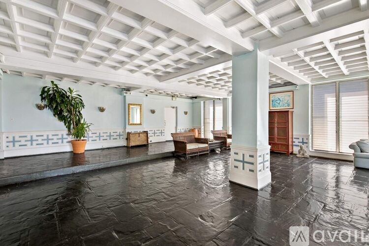 A spacious room with a black stone floor and white ceiling.