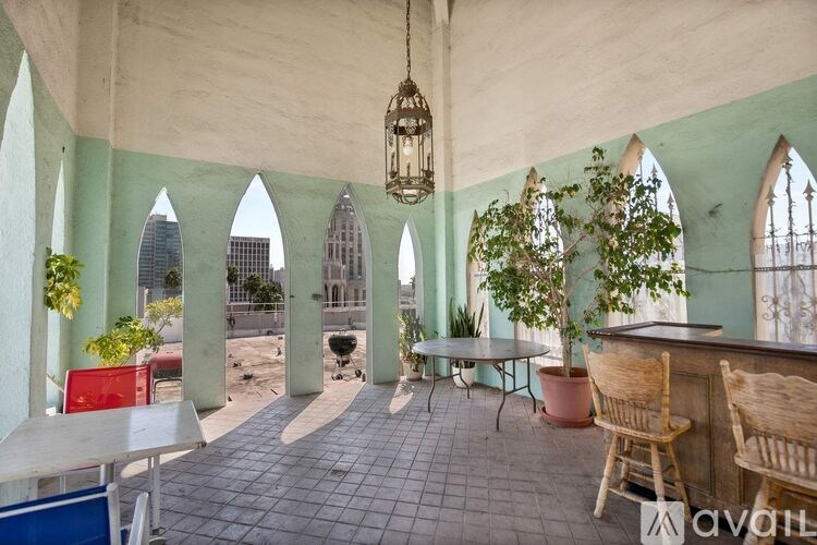 A balcony with a table and chairs overlooking a cityscape.