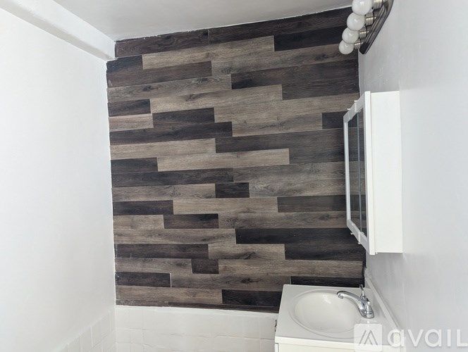 A bathroom with a wood panel wall and a white toilet.