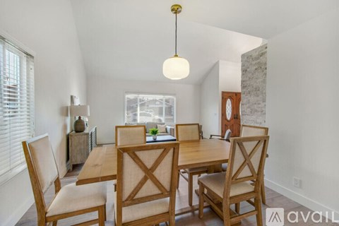 A dining room with a wooden table and chairs.