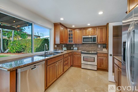 A kitchen with wooden cabinets and a stainless steel refrigerator.