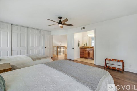 A bedroom with a large bed and a ceiling fan.