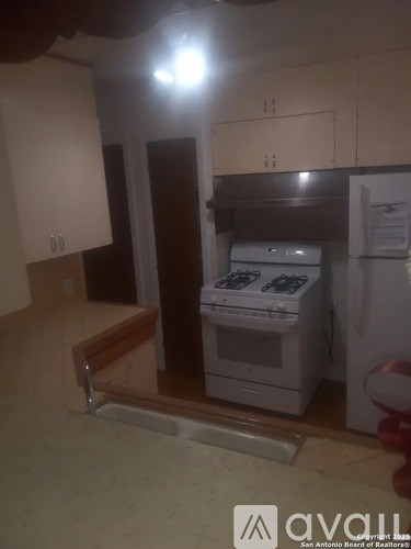 A kitchen with a white oven and a white fridge.