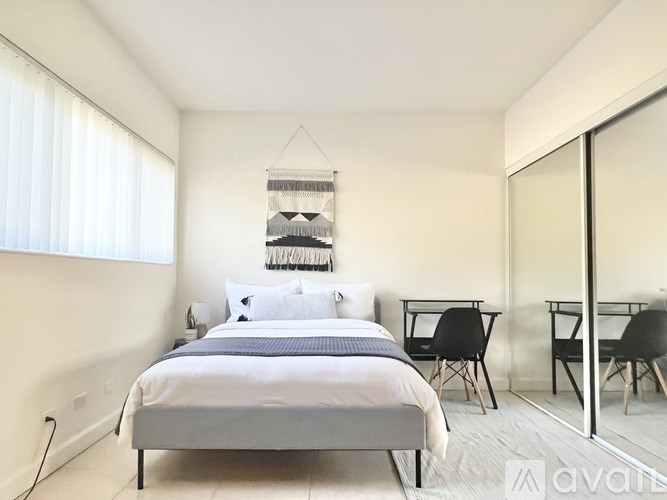 A bedroom with a bed, desk, and chair.