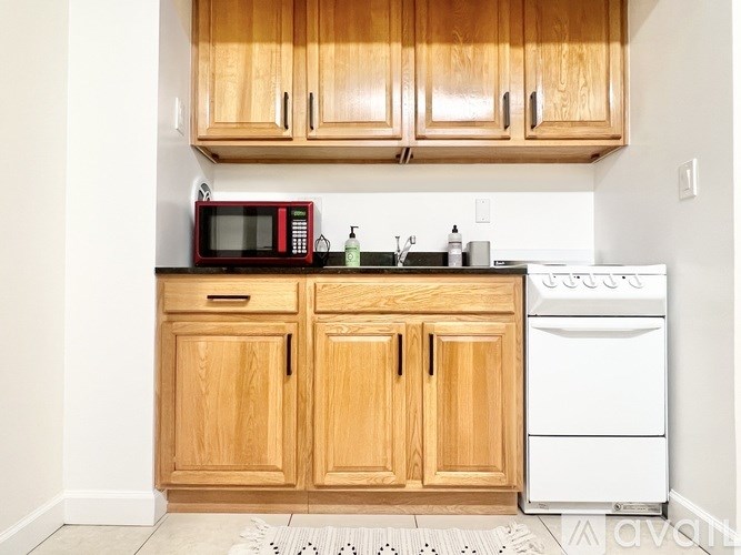 A kitchen with wooden cabinets and a white dishwasher.
