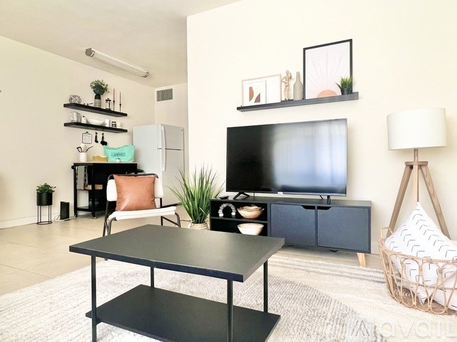 A modern living room with a black coffee table and a flat screen TV.