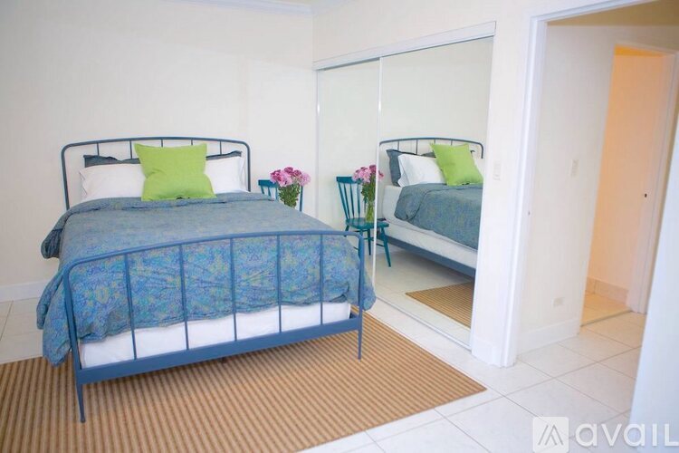 A bedroom with two beds and a mirror.