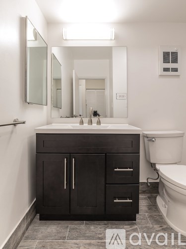 A bathroom with a sink, mirror, and toilet.