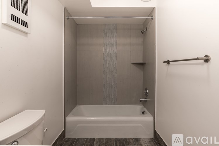 A small white bathroom with a tub and toilet.