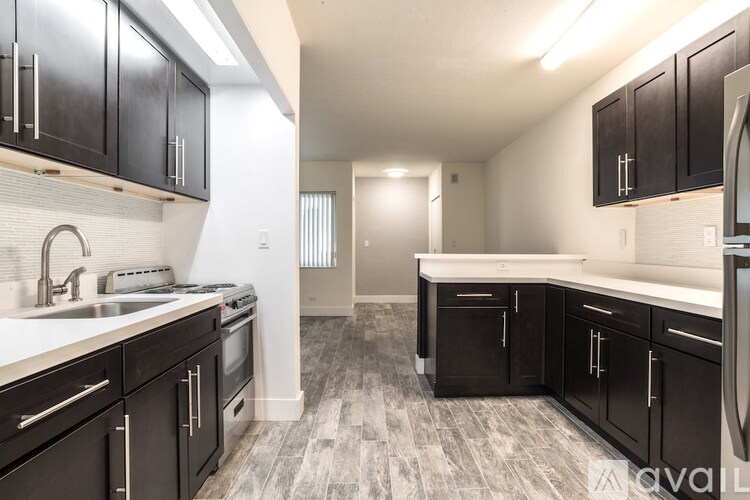 A kitchen with black cabinets and a white countertop.