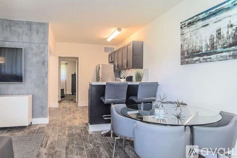 A modern living room with a grey sofa and a glass table.