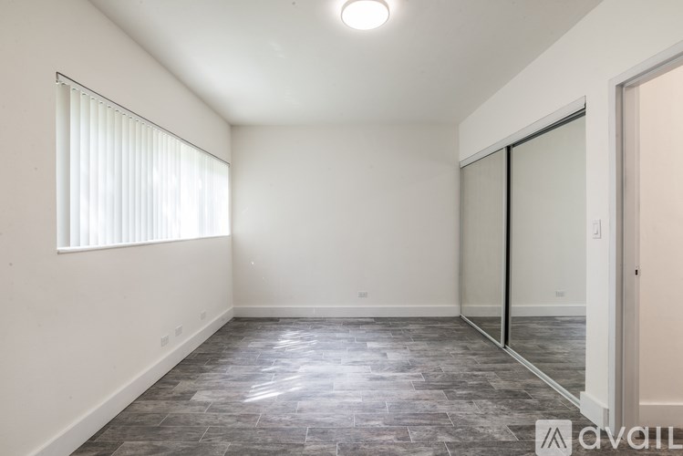 A room with a sliding glass door and a window with blinds.