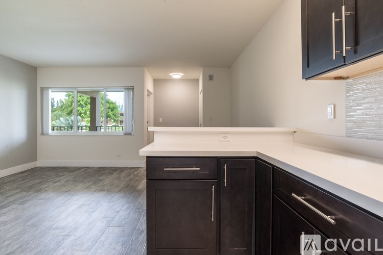 A kitchen with dark wood cabinets and a white countertop.