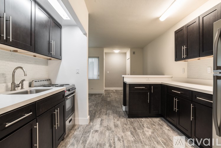 A kitchen with black cabinets and a white countertop.