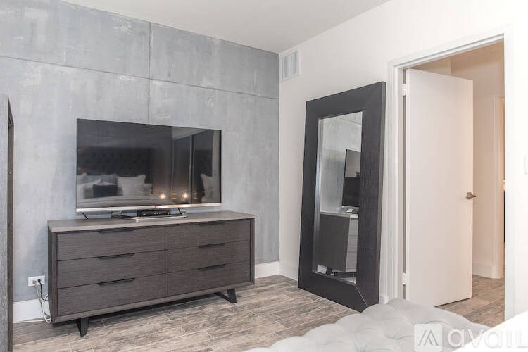 A modern living room with a grey cabinet and a flat screen TV on it.