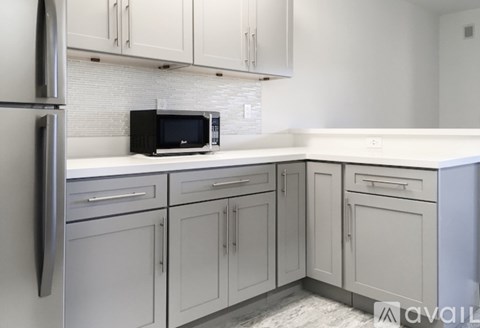 A kitchen with a black microwave oven on the counter.