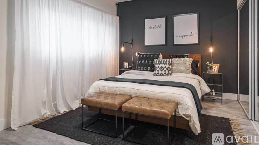 A bedroom with a large bed and a bench in front of it.