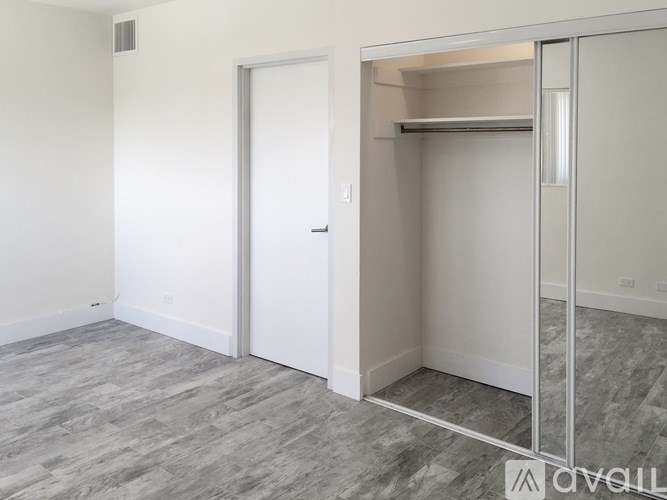 A room with a white door and a grey floor.