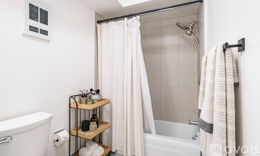 A white bathroom with a white tub and a white shower curtain.