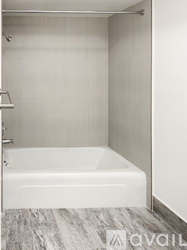 A white bathtub in a bathroom with a grey floor.