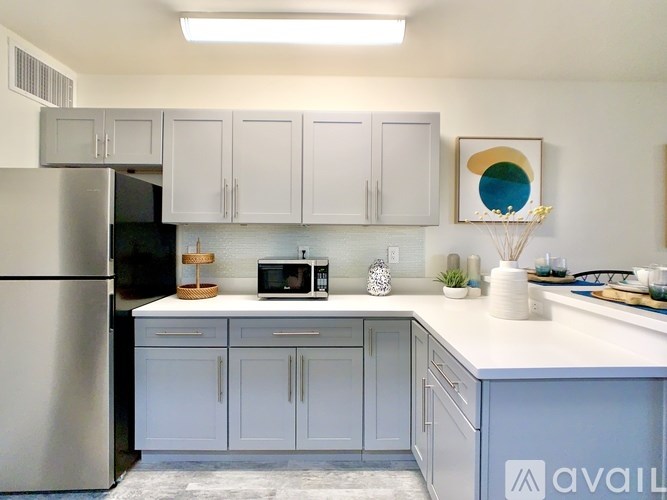 A kitchen with a refrigerator, cabinets, and a countertop.